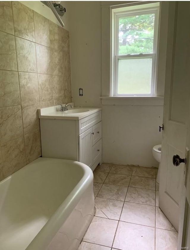 bathroom featuring vanity, toilet, a tub, and tile patterned floors