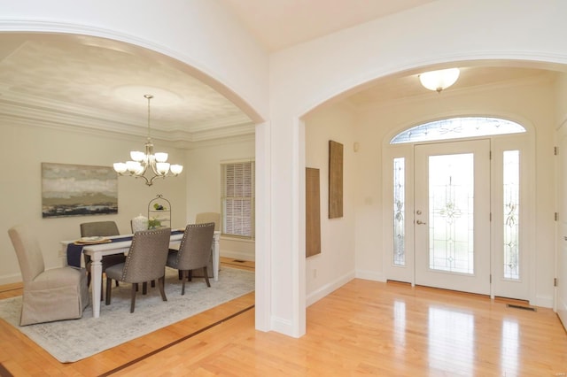 foyer entrance with a chandelier, light wood-type flooring, and a healthy amount of sunlight