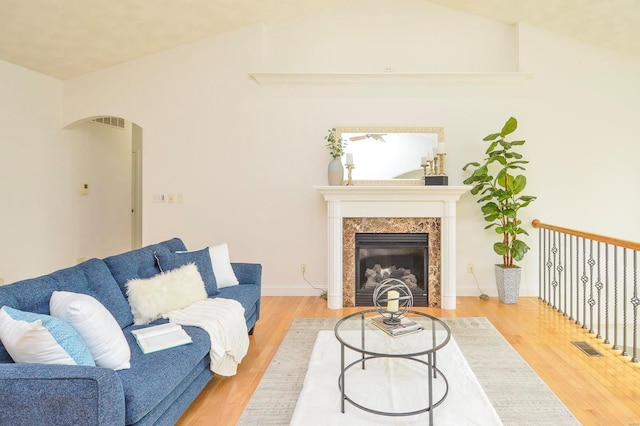 living room featuring lofted ceiling, hardwood / wood-style floors, and a fireplace