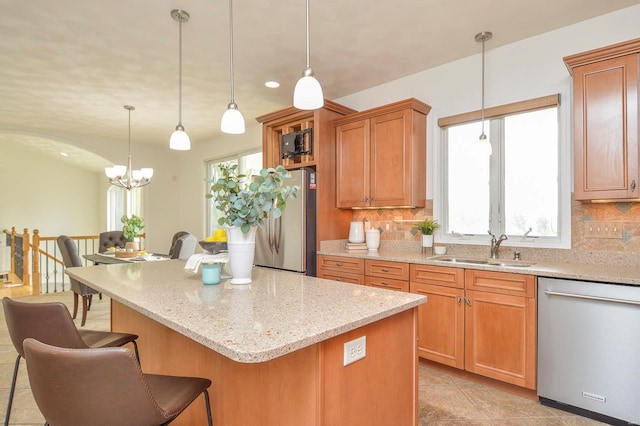 kitchen featuring sink, a notable chandelier, decorative light fixtures, appliances with stainless steel finishes, and tasteful backsplash