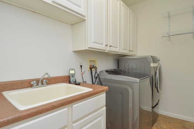 laundry room featuring sink, light tile patterned flooring, separate washer and dryer, and cabinets