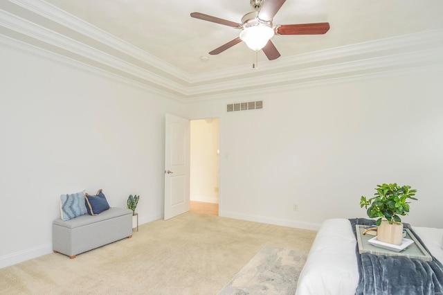 sitting room featuring light carpet, ornamental molding, a tray ceiling, and ceiling fan