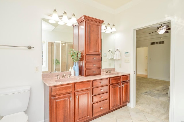 bathroom with toilet, tile patterned flooring, a shower with shower door, ornamental molding, and vanity