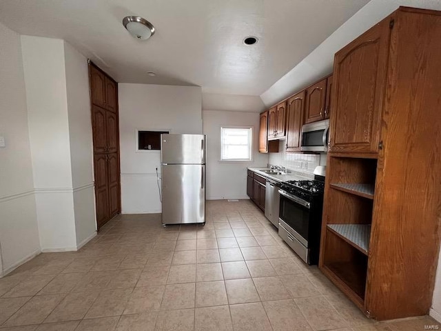 kitchen featuring sink, tasteful backsplash, stainless steel appliances, and light tile patterned floors