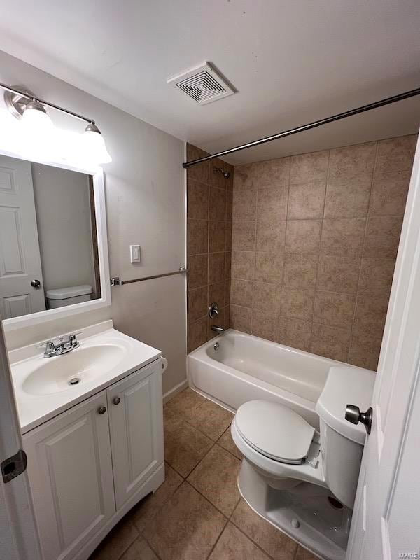 full bathroom with toilet, tiled shower / bath combo, vanity, and tile patterned floors