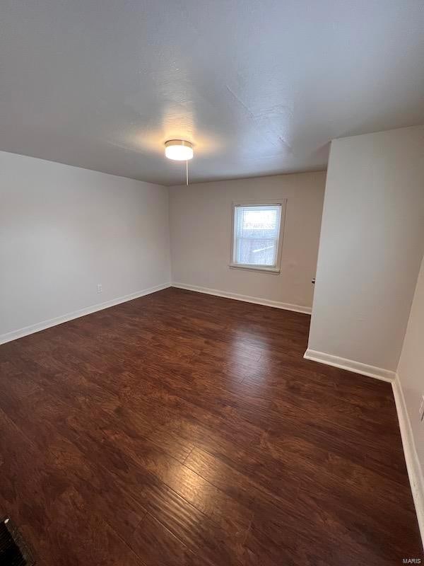 unfurnished room featuring dark wood-type flooring