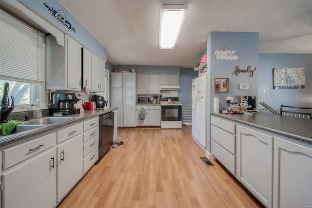 kitchen featuring white appliances, light hardwood / wood-style floors, a textured ceiling, and white cabinets