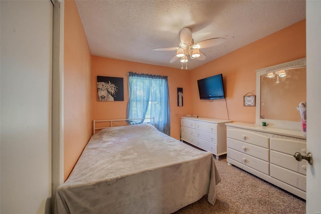 carpeted bedroom featuring a textured ceiling and ceiling fan