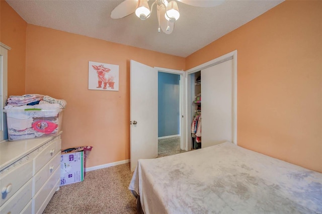 carpeted bedroom featuring a textured ceiling, a closet, and ceiling fan