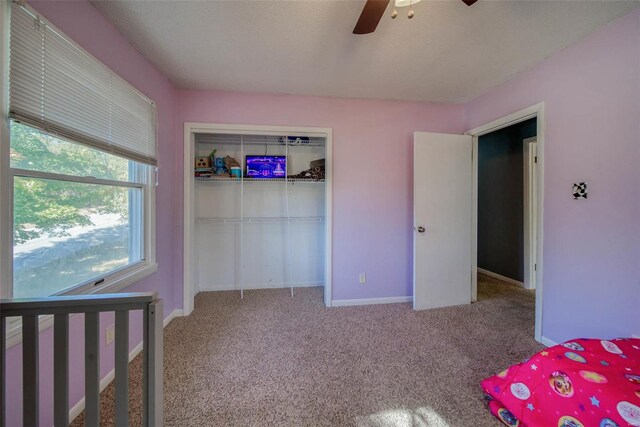 unfurnished bedroom with light carpet, a closet, and ceiling fan