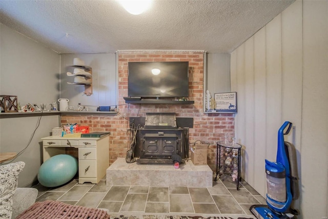 interior space with a textured ceiling and a wood stove