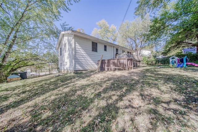 rear view of house with a yard and a deck