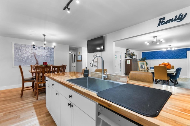 kitchen with hanging light fixtures, sink, white cabinets, and a chandelier