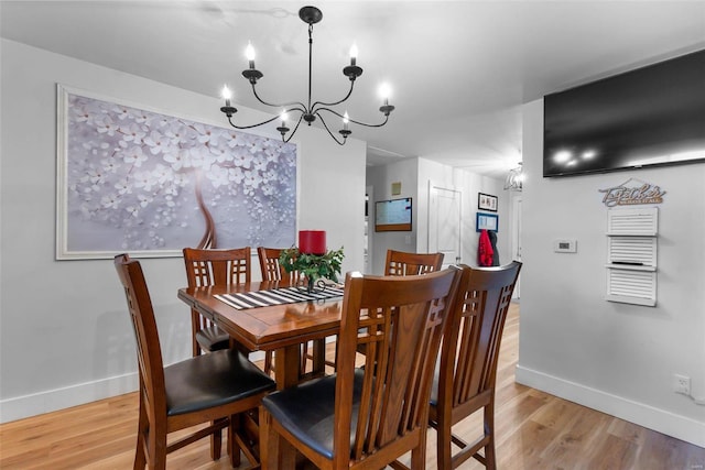 dining area featuring light hardwood / wood-style floors and an inviting chandelier