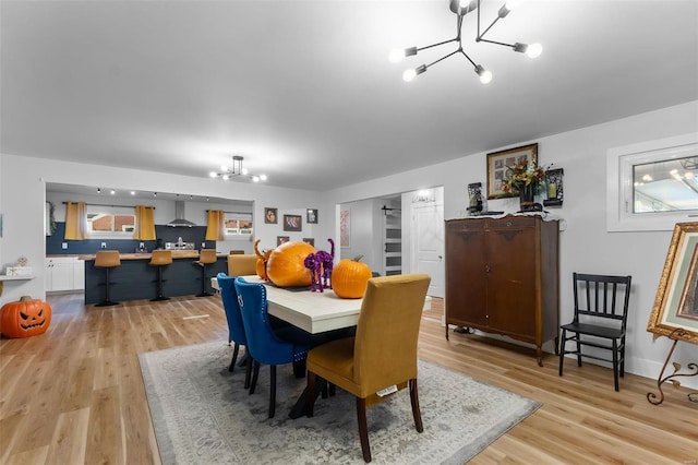 dining area featuring light hardwood / wood-style floors, an inviting chandelier, and a wealth of natural light