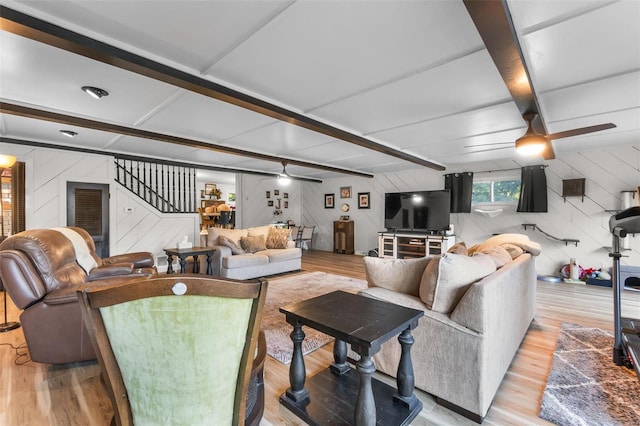 living room with beam ceiling, ceiling fan, light hardwood / wood-style floors, and wood walls