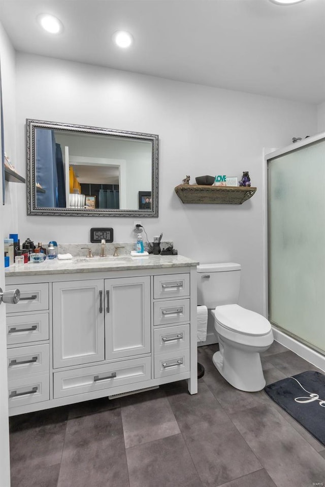 bathroom with toilet, vanity, and walk in shower