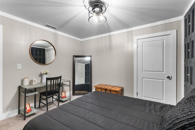 carpeted bedroom with a closet and crown molding