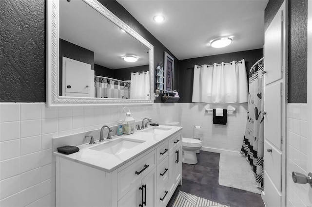 bathroom featuring tile patterned flooring, vanity, tile walls, and toilet