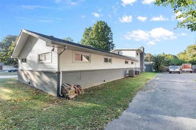 view of property exterior featuring a lawn and central AC