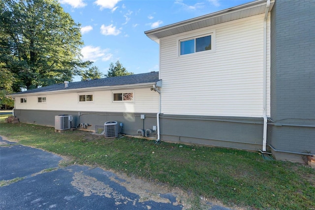 view of home's exterior featuring central air condition unit and a yard