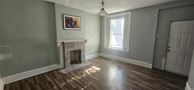 unfurnished living room with a fireplace, dark hardwood / wood-style flooring, and a textured ceiling