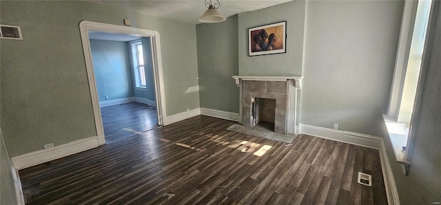 unfurnished living room featuring dark hardwood / wood-style floors and a fireplace