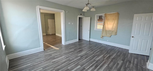 unfurnished bedroom with dark hardwood / wood-style flooring