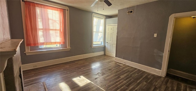 unfurnished room with a textured ceiling, dark hardwood / wood-style floors, and ceiling fan