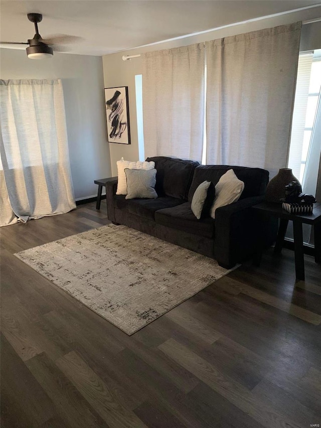 living room with dark wood-type flooring and ceiling fan