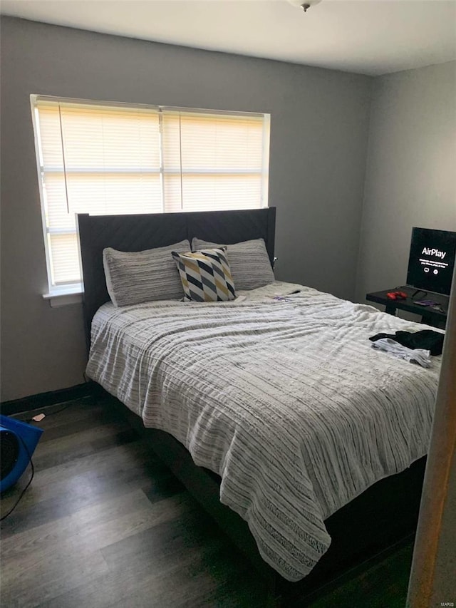 bedroom with dark hardwood / wood-style floors