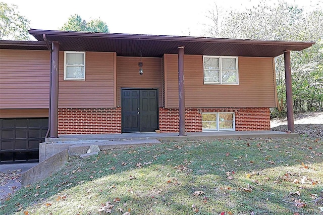 back of house with a garage and a lawn