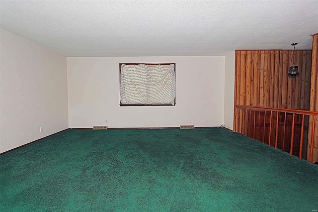 carpeted empty room with a textured ceiling