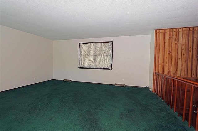 unfurnished room with a textured ceiling and carpet floors