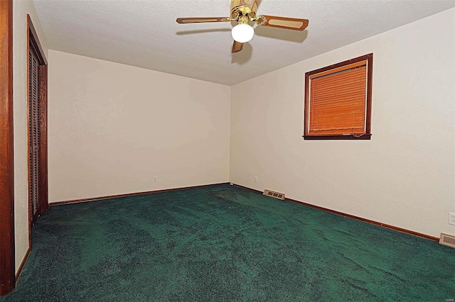 carpeted spare room with a textured ceiling and ceiling fan