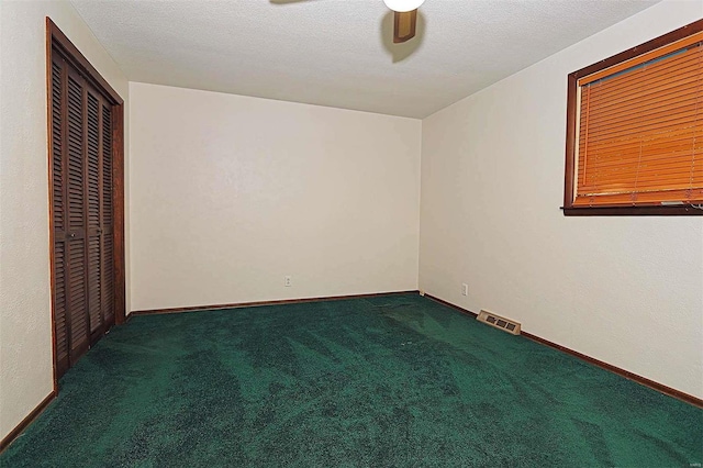 carpeted empty room with a textured ceiling and ceiling fan