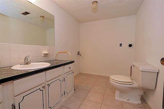 bathroom with vanity, toilet, tasteful backsplash, and tile patterned flooring