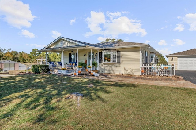 rear view of property featuring covered porch, a garage, ceiling fan, and a lawn