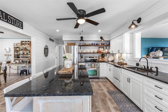 kitchen with white cabinets, appliances with stainless steel finishes, sink, and wood-type flooring