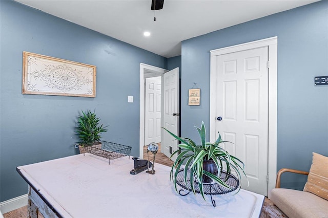 home office with wood-type flooring and ceiling fan