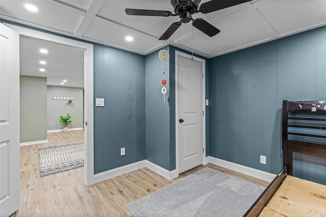 interior space with hardwood / wood-style flooring, ceiling fan, and wooden walls