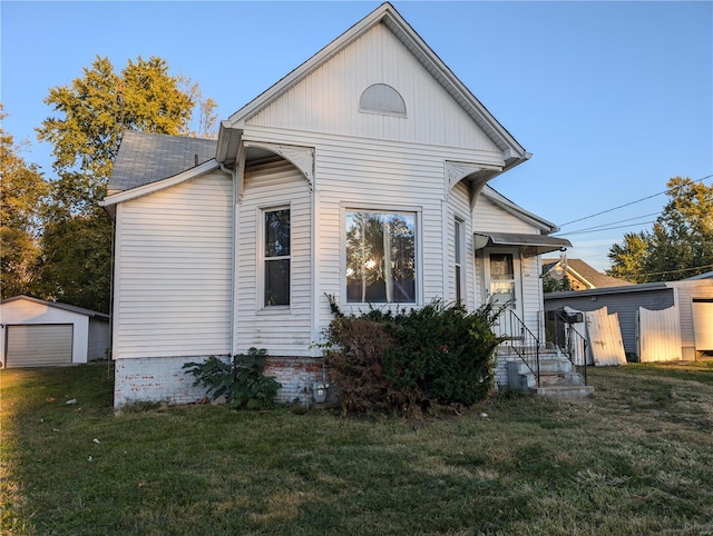 view of side of property with an outdoor structure, a yard, and a garage