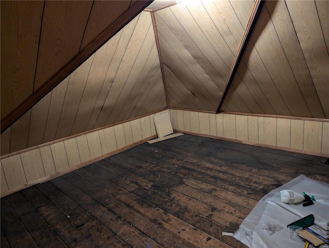 bonus room with wooden walls and dark hardwood / wood-style floors