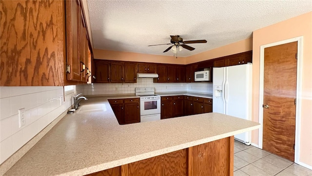 kitchen with white appliances, sink, backsplash, a textured ceiling, and kitchen peninsula