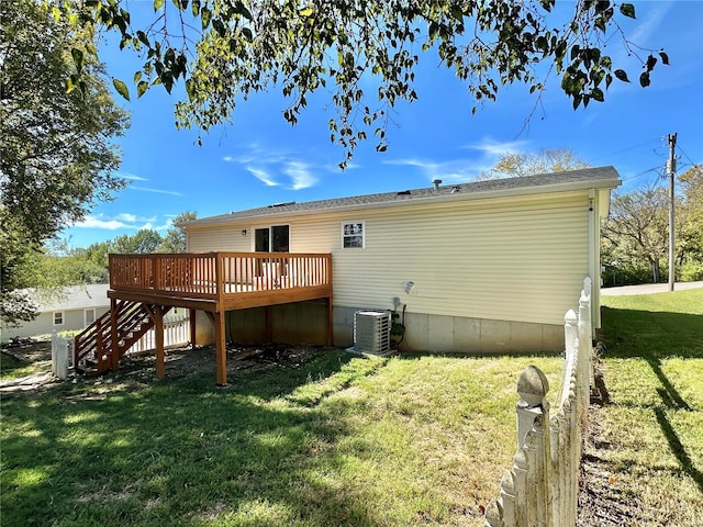 rear view of house featuring a yard, cooling unit, and a wooden deck