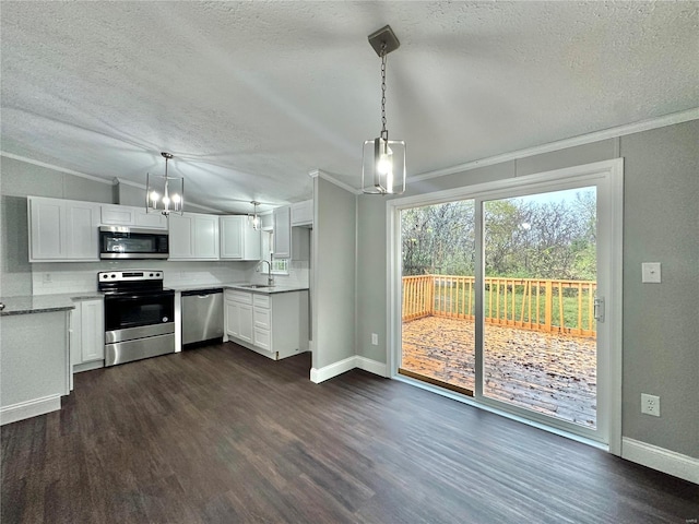 kitchen with dark wood-type flooring, stainless steel appliances, pendant lighting, and white cabinets