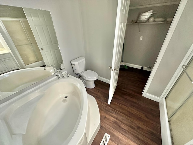 bathroom featuring toilet, hardwood / wood-style flooring, and walk in shower