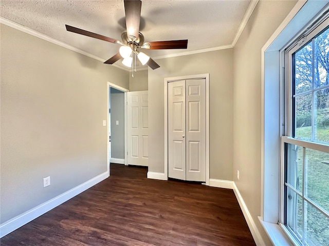 unfurnished bedroom with ceiling fan, a textured ceiling, dark hardwood / wood-style flooring, and ornamental molding