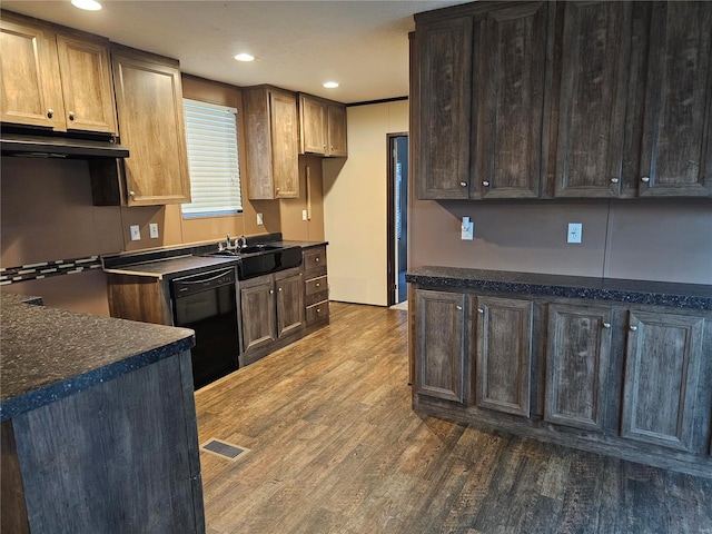 kitchen featuring black dishwasher, sink, dark brown cabinets, and dark hardwood / wood-style flooring