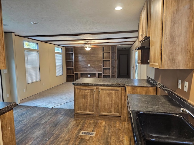 kitchen with kitchen peninsula, sink, dark hardwood / wood-style flooring, a textured ceiling, and ceiling fan